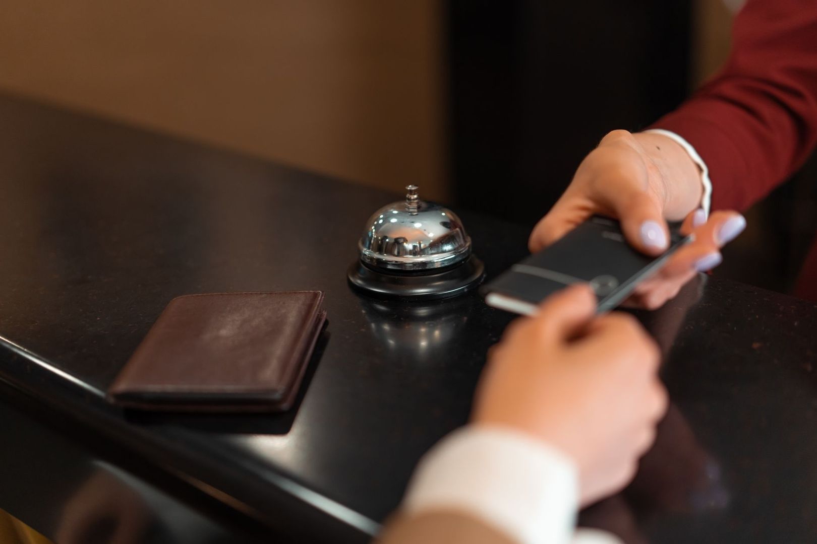 Client présentant un téléphone au comptoir de la conciergerie d’un hôtel
